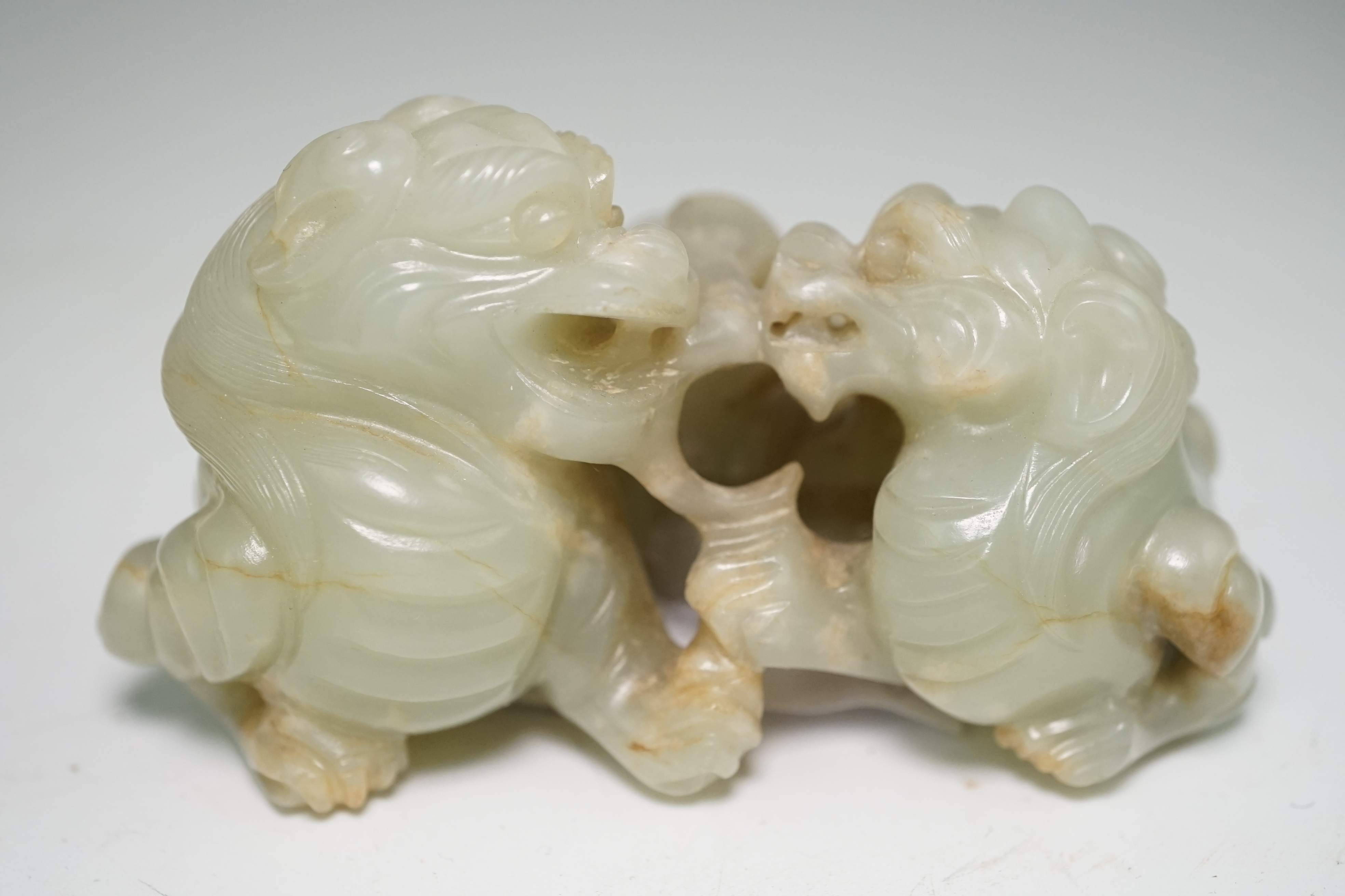 A Chinese celadon and russet jade group of two lion-dogs, 19th century